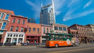 tour trolley passing by buildings, carrying passengers