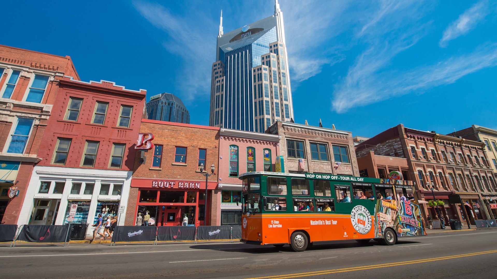 tour trolley passing by buildings, carrying passengers