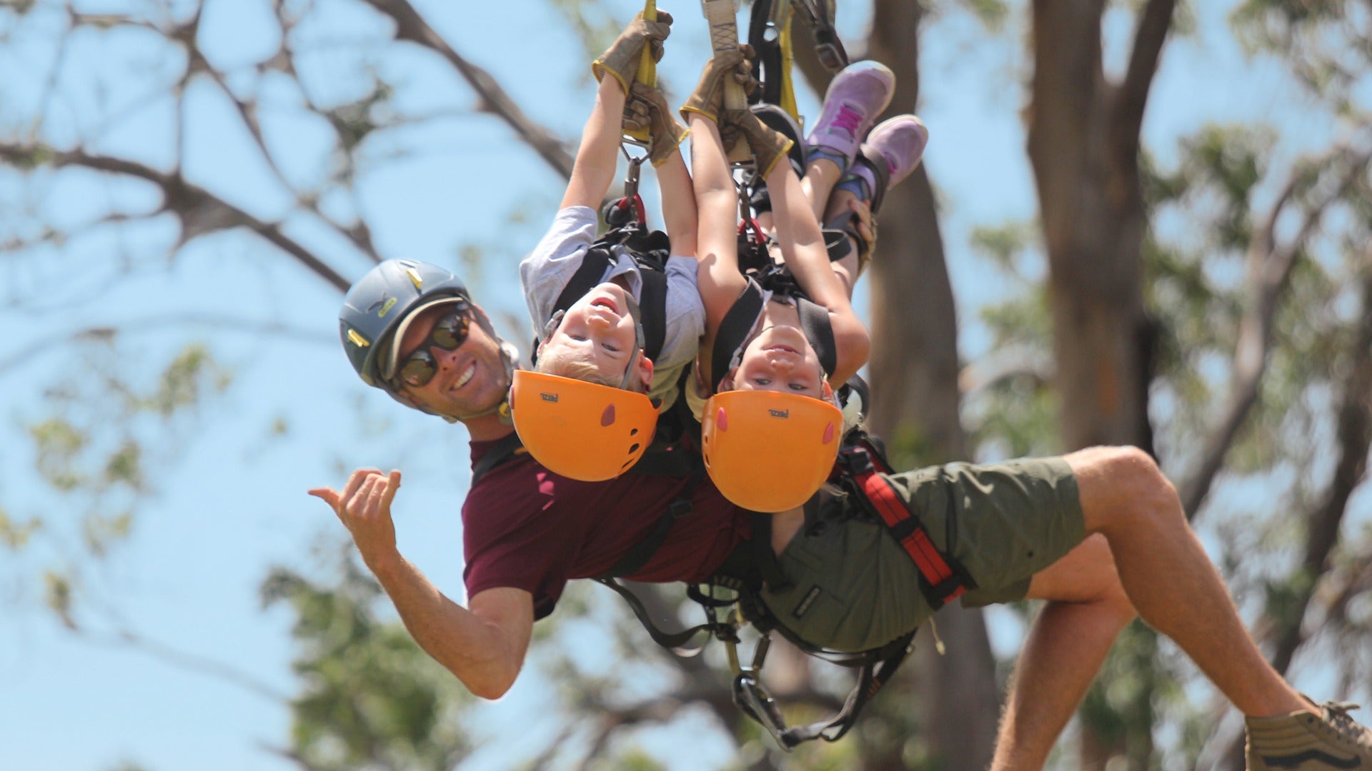 a family going down a zipline with two kids and an adult