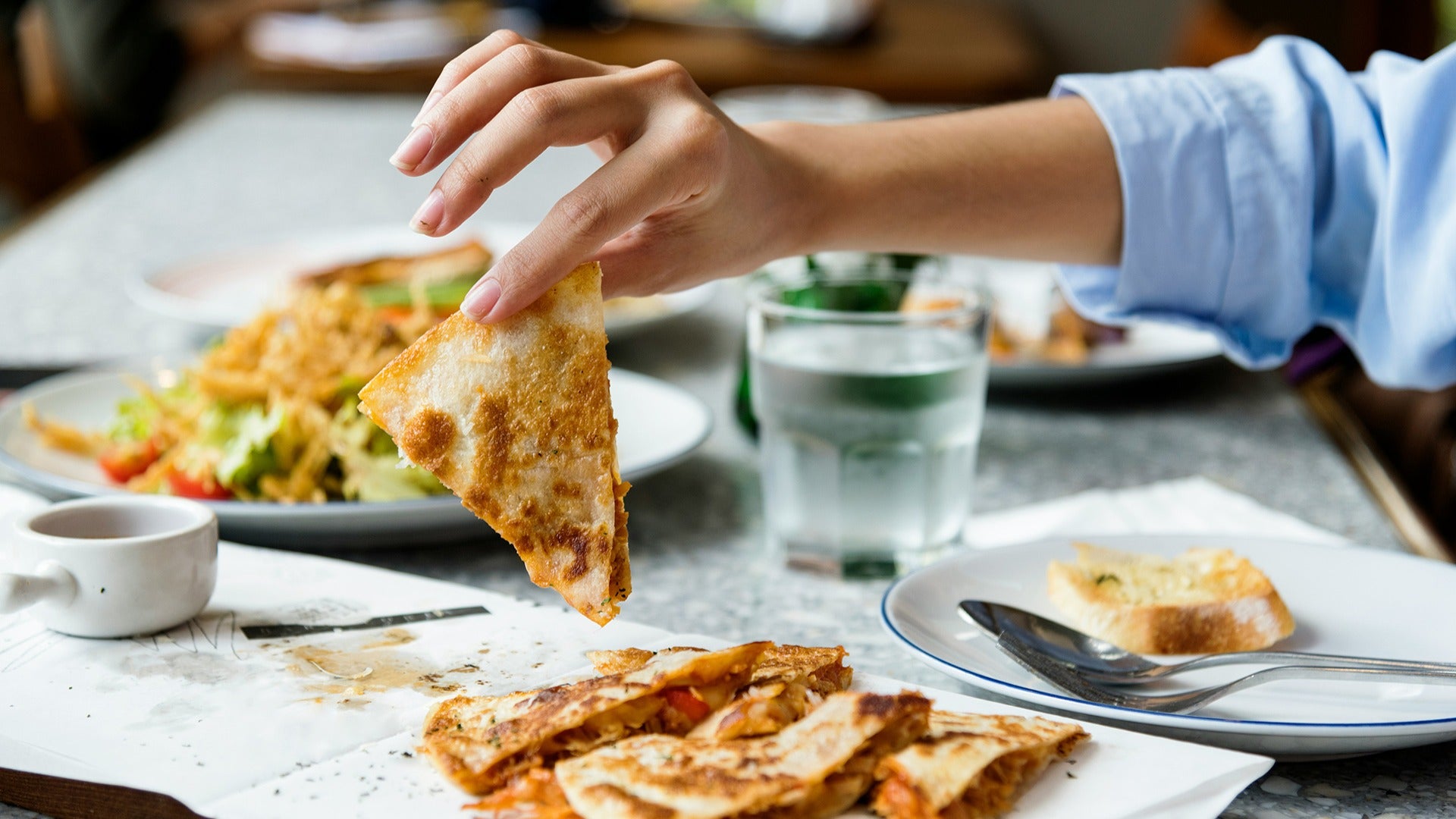 mexican food including quesadillas with someone picking one up
