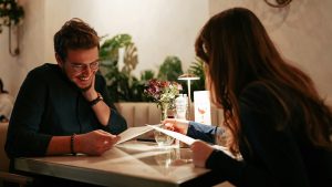 couple on a date in a restaurant looking at menus