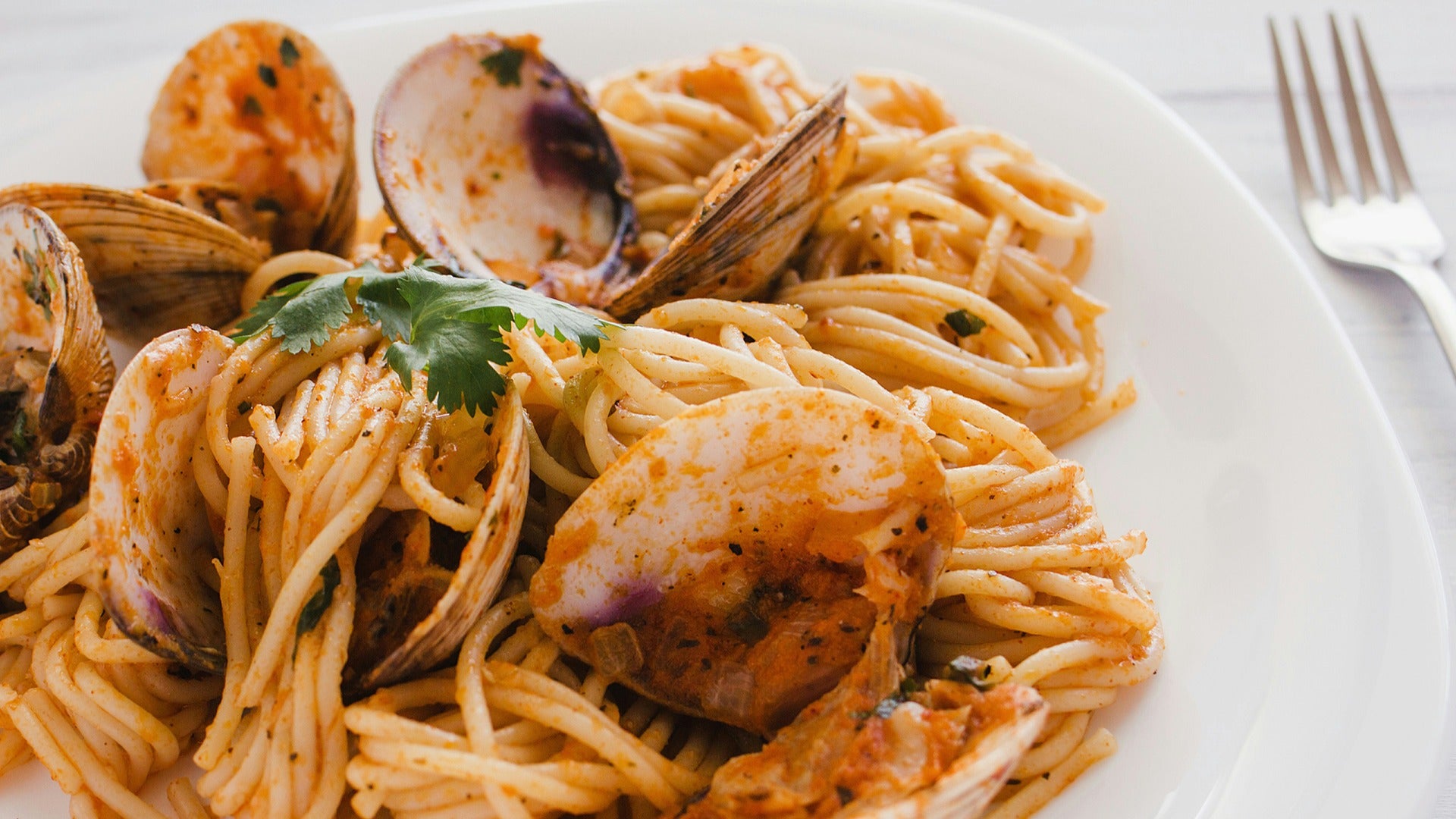 seafood pasta with clams and a fork on the side