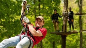 man on a zipline in a forest