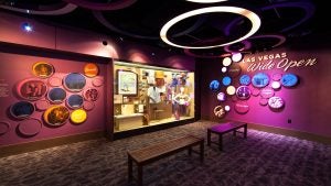 museum with exhibit of clothes, seating area, and details on the walls