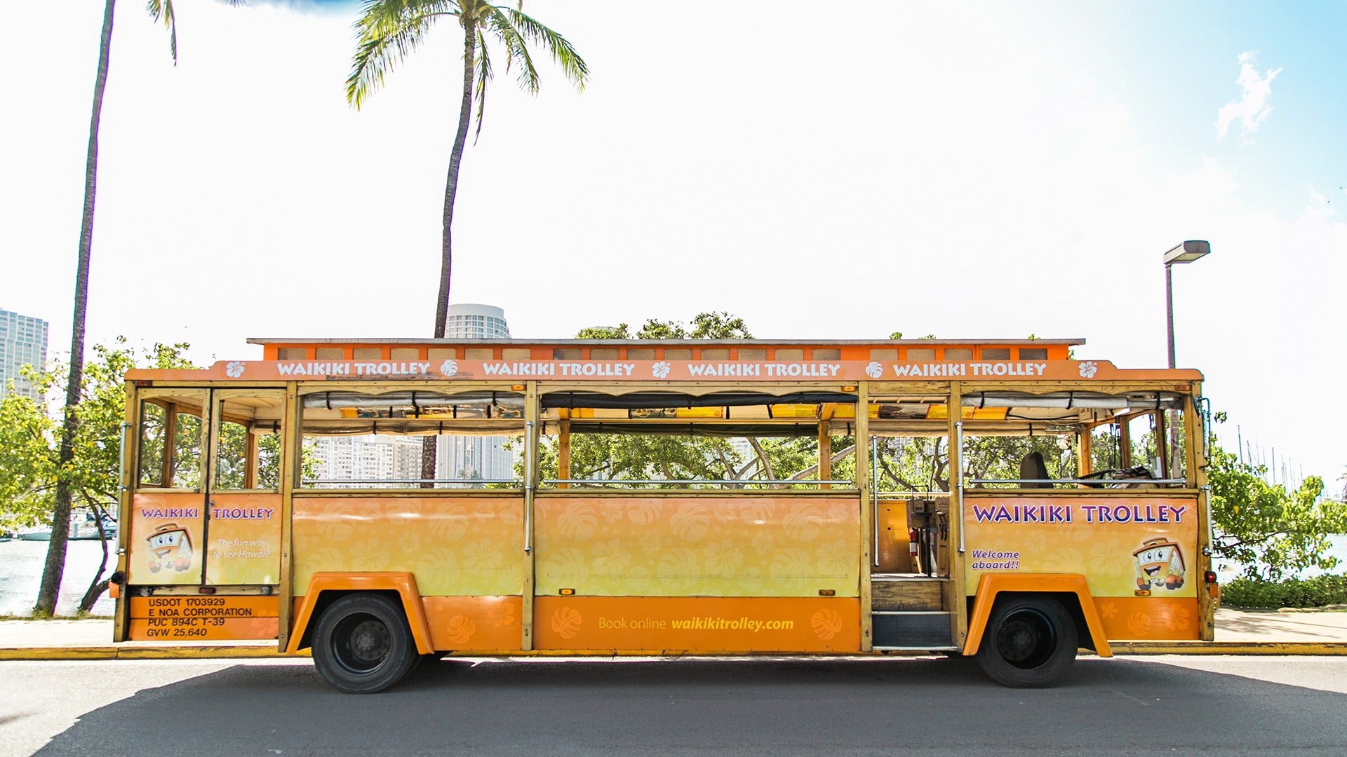 a tour trolley with palm trees at the back
