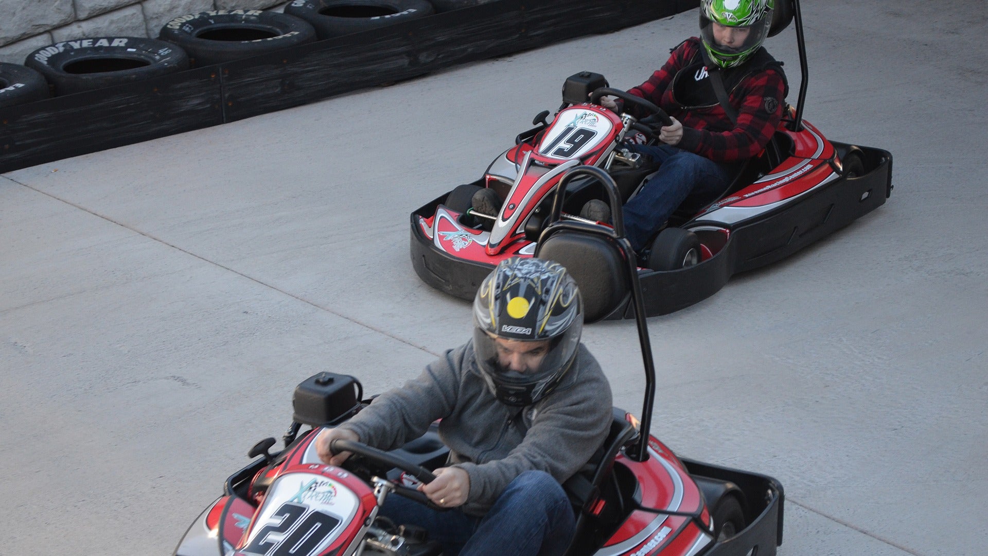 two people riding go karts on a track