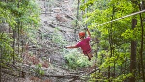 man on a zipline down the mountain