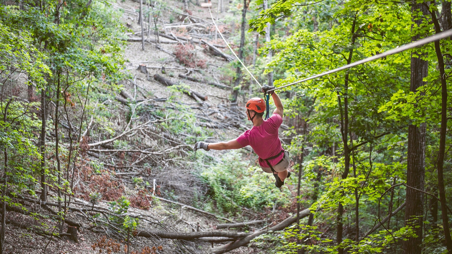 man on a zipline down the mountain