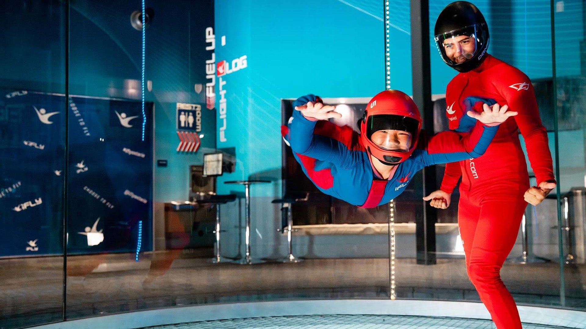 kid in an indoor skydiving facility with an instructor