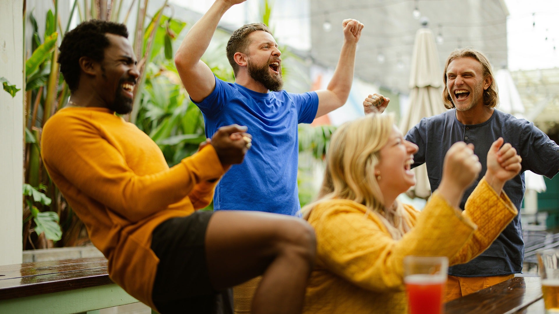 people in a sports bar cheering and drinking alcohol