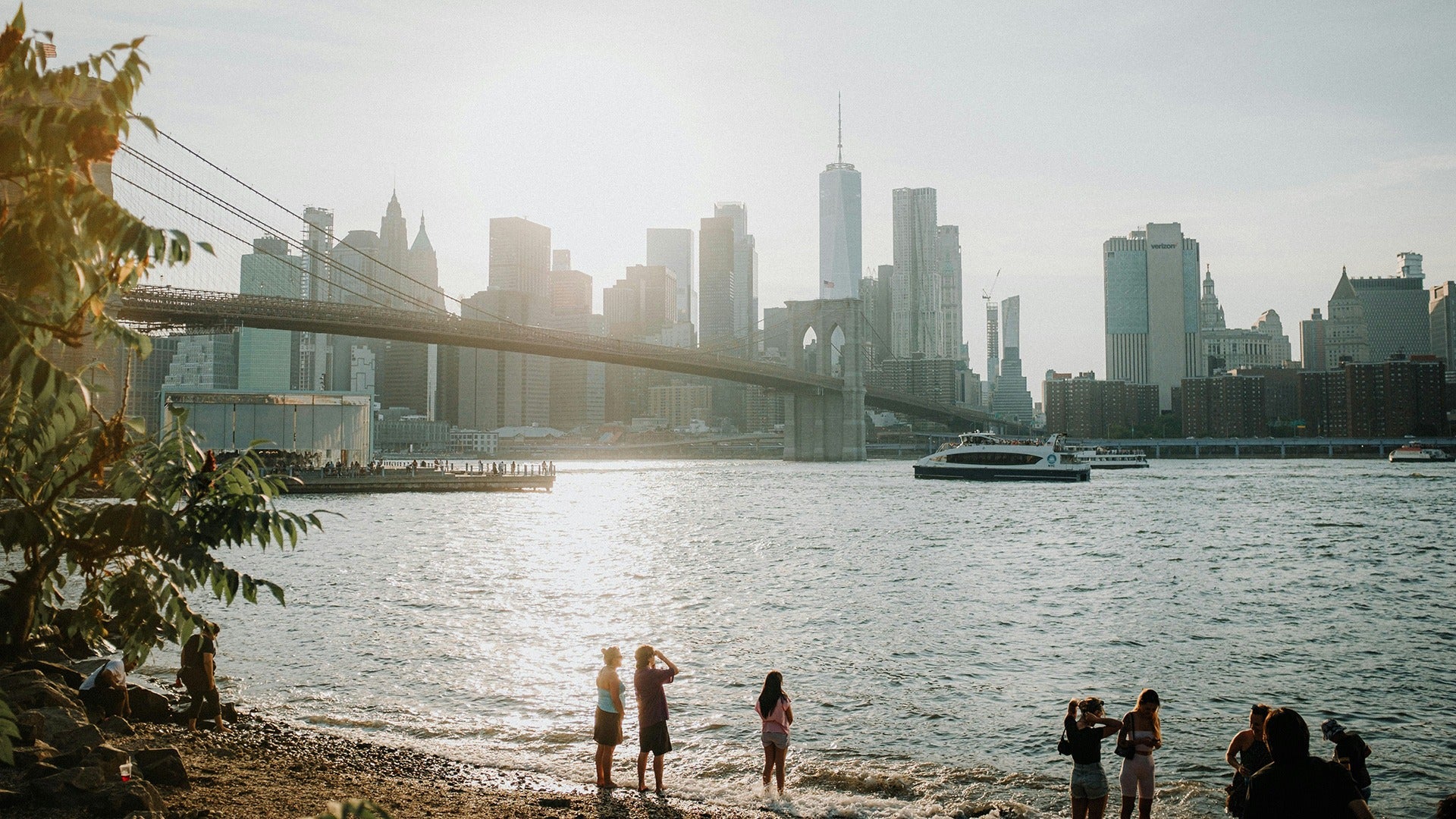 View of Lower Manhattan from Brooklyn Bridge Park with people on the shore