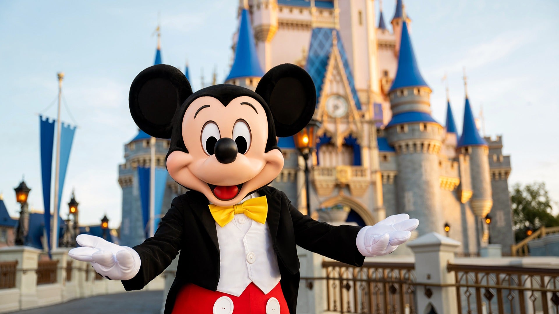 mickey mouse standing in front of cinderella's castle in disney