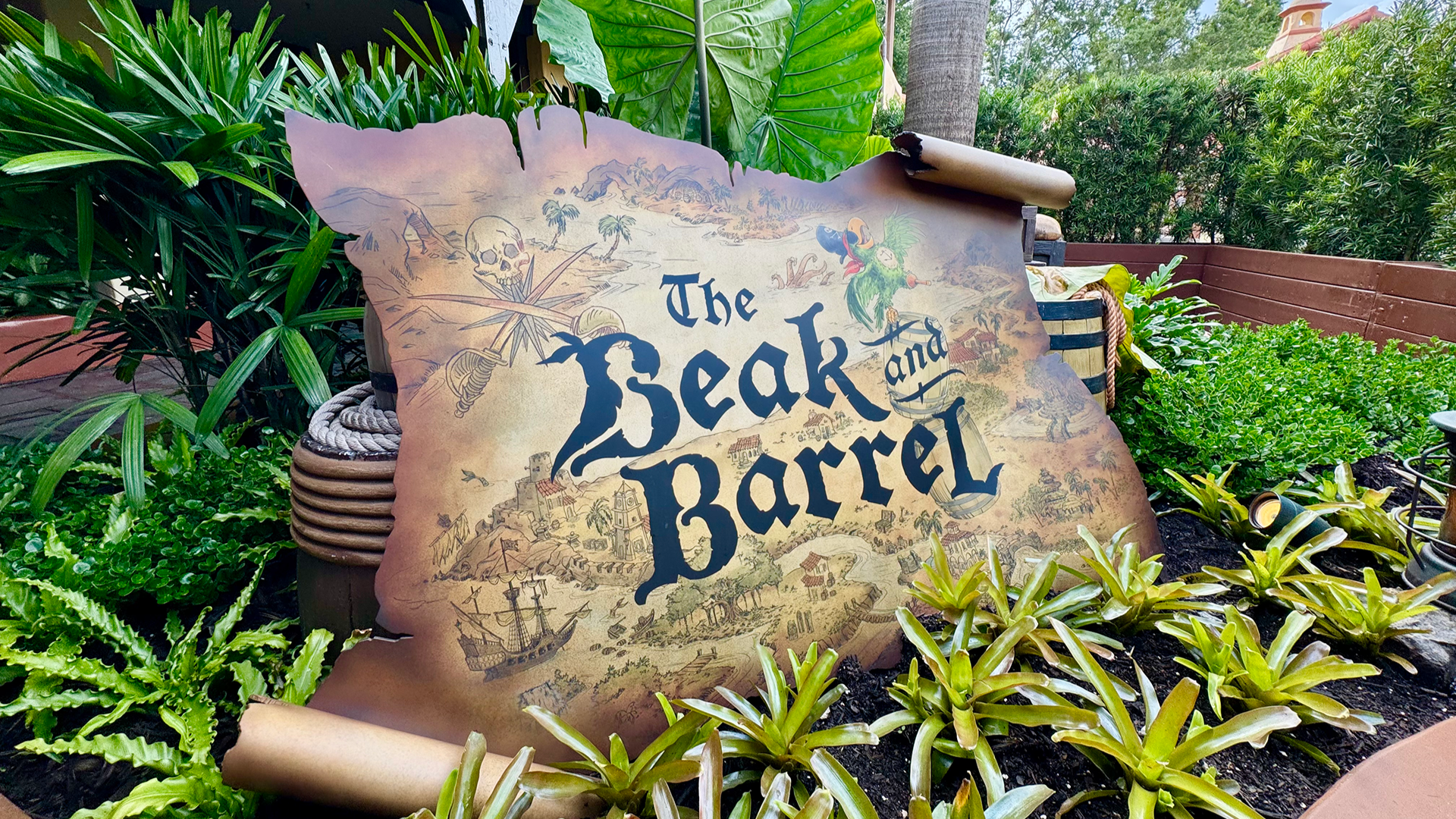 a restaurant signage surrounded by plants