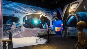 a space themed exhibit with a spaceship and an alien