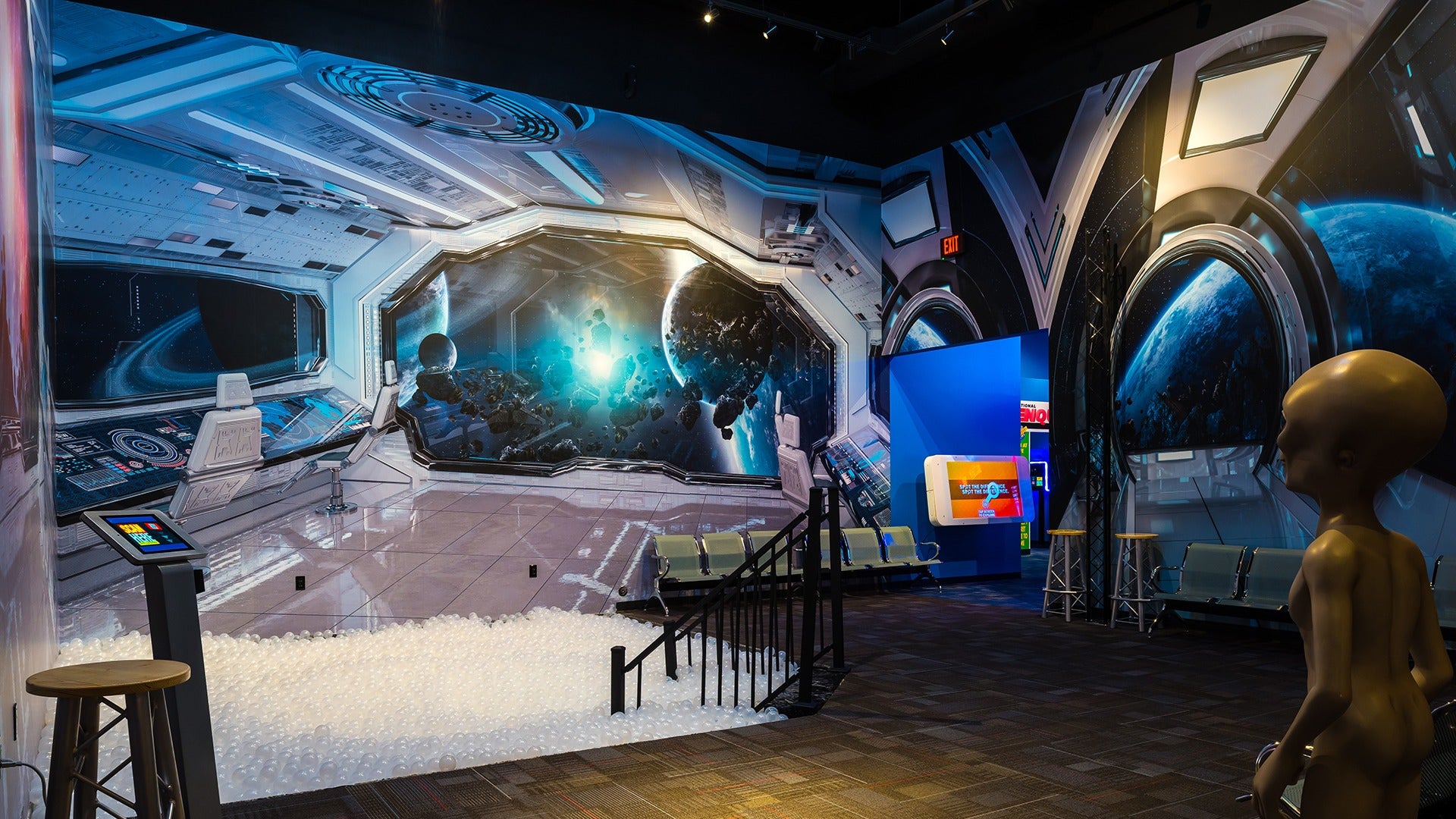 a space themed exhibit with a spaceship and an alien