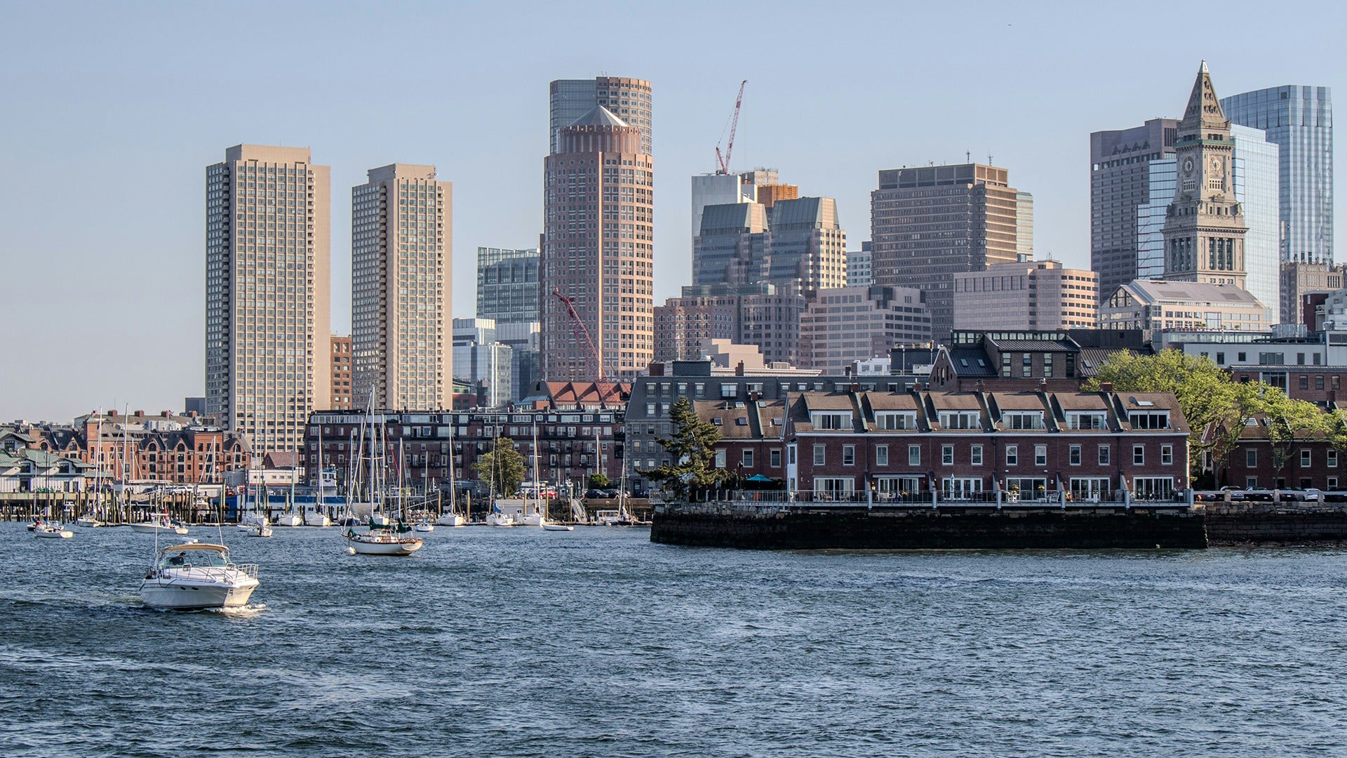 a harbor with a view of the city behind and boats on the water