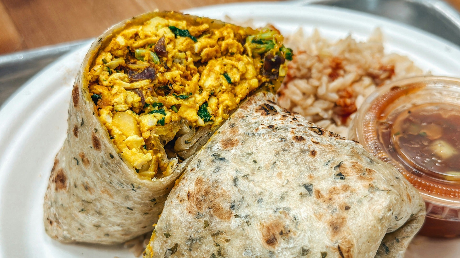 burritos with a side of rice and sauce