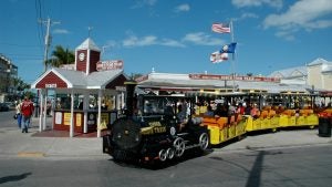 people aboard a train tour with the ticketing station at the back