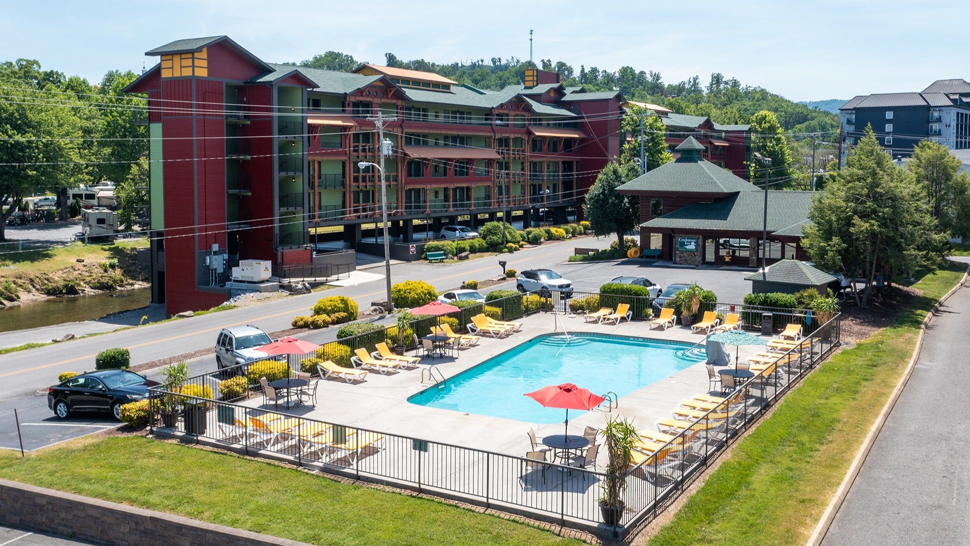 a hotel with cars parked around it and a pool area