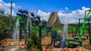 A train full of riders racing toward the camera, feet dangling and expressions full of thrill