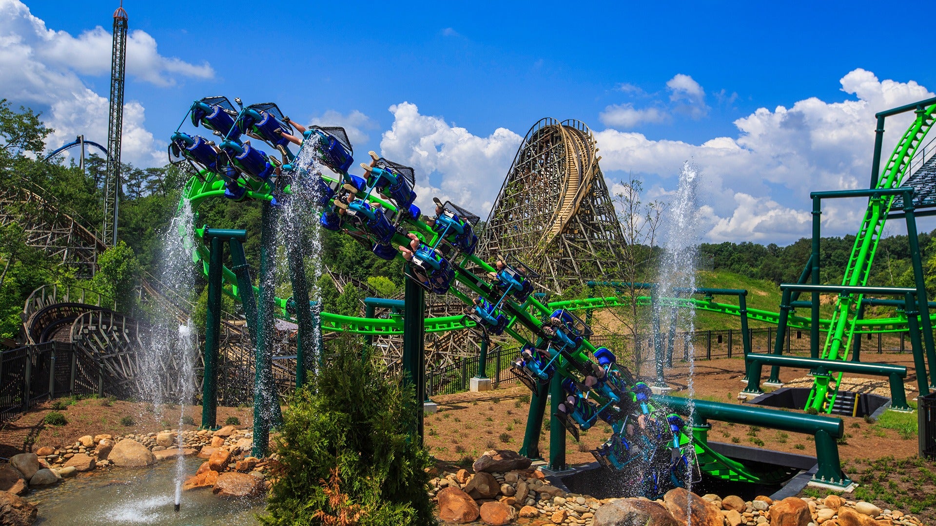 A train full of riders racing toward the camera, feet dangling and expressions full of thrill