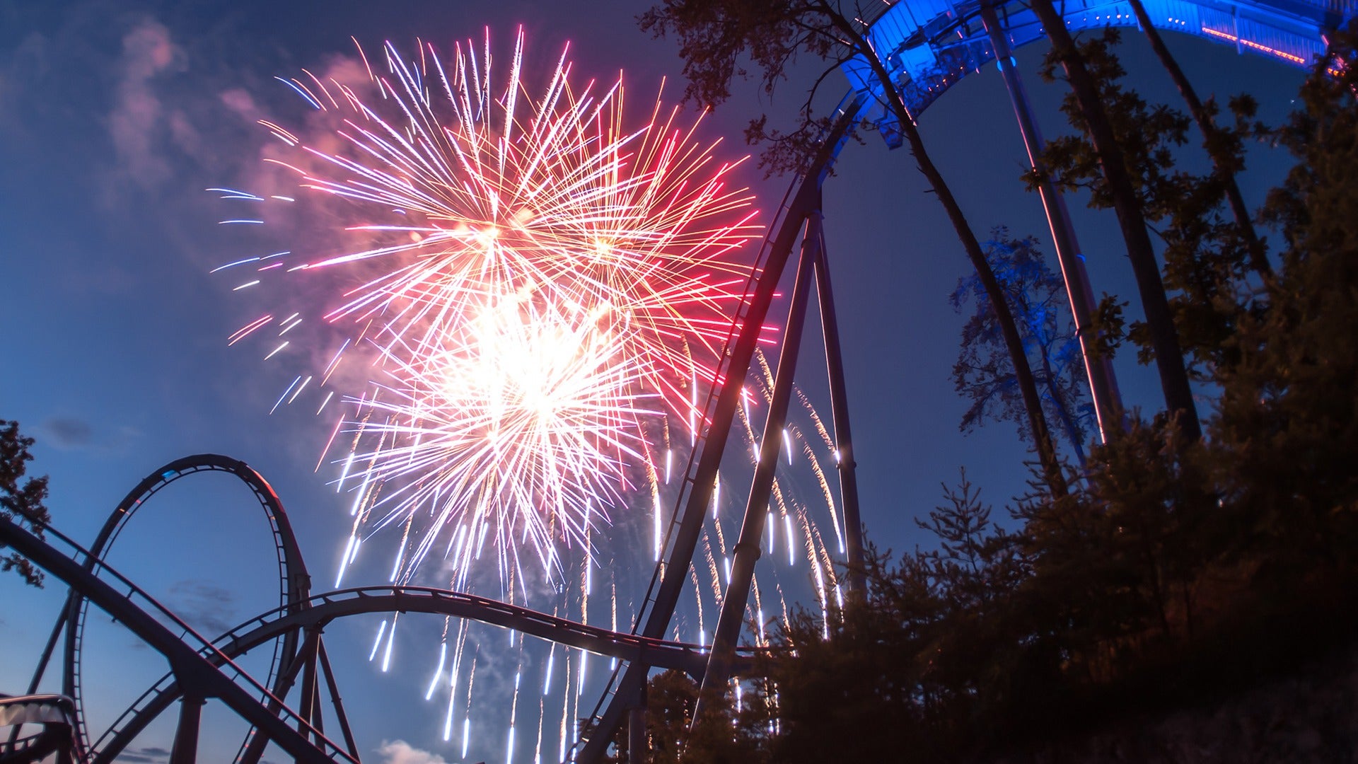 fireworks seen from a roller coaster at night