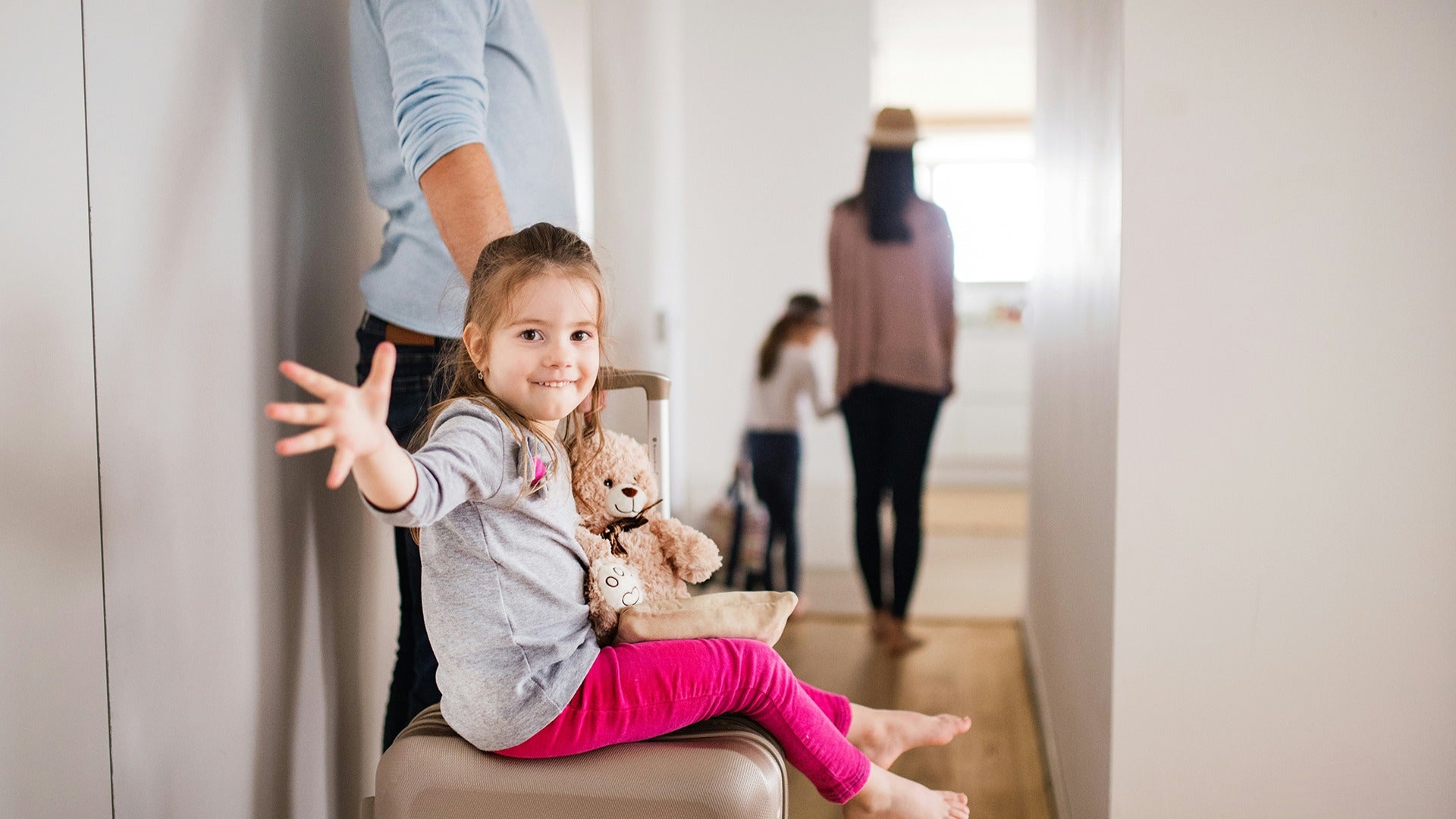 a family checking into a hotel, little girl holding a teddy bear