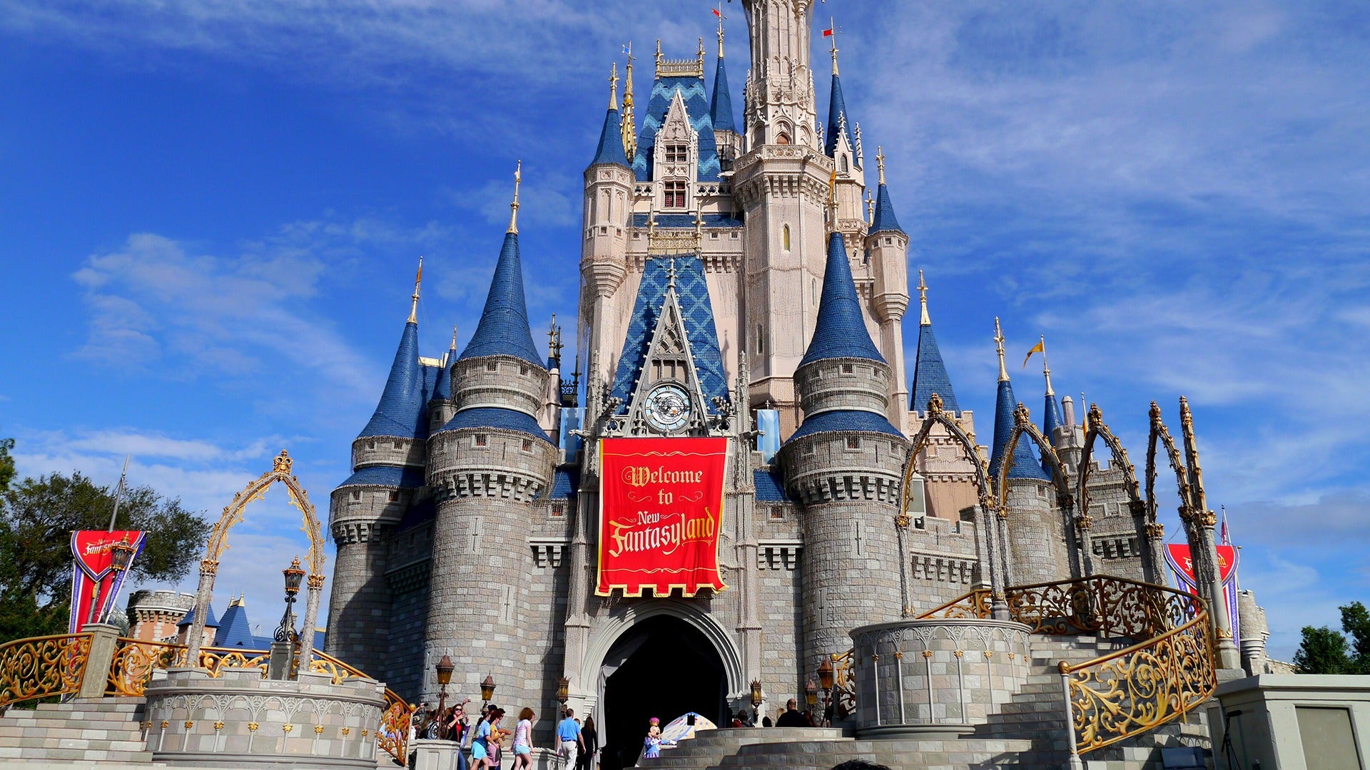 a castle with a welcome signage and people entering it