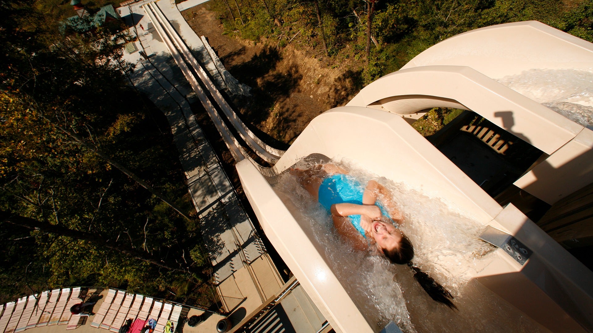 a girl going down a high slide in a waterpark