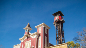a tower drop with passengers on it in a theme park