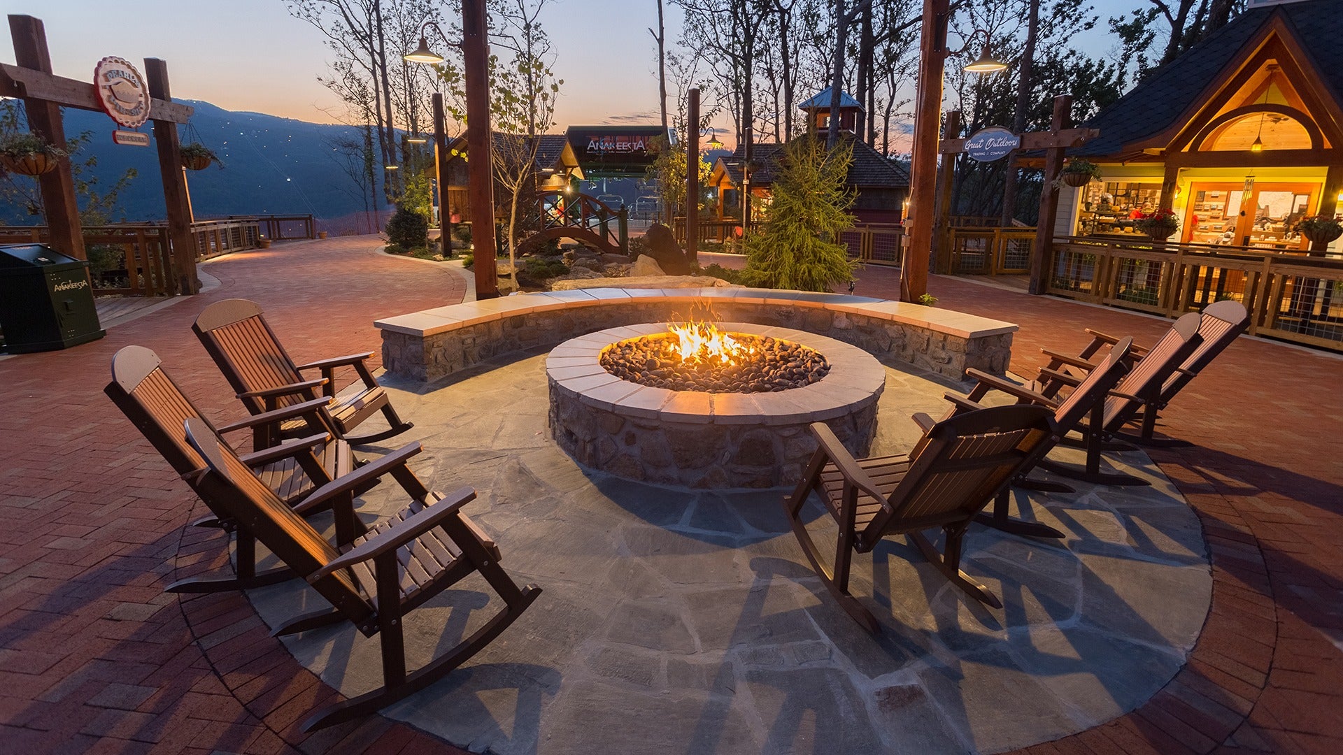 firepit with outdoor rocking chairs and a view of the mountains at the back