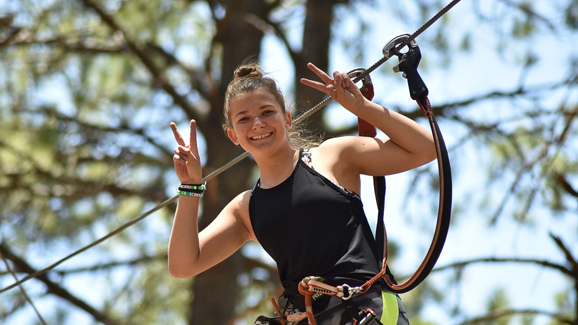 a woman in a zipline harness smiling