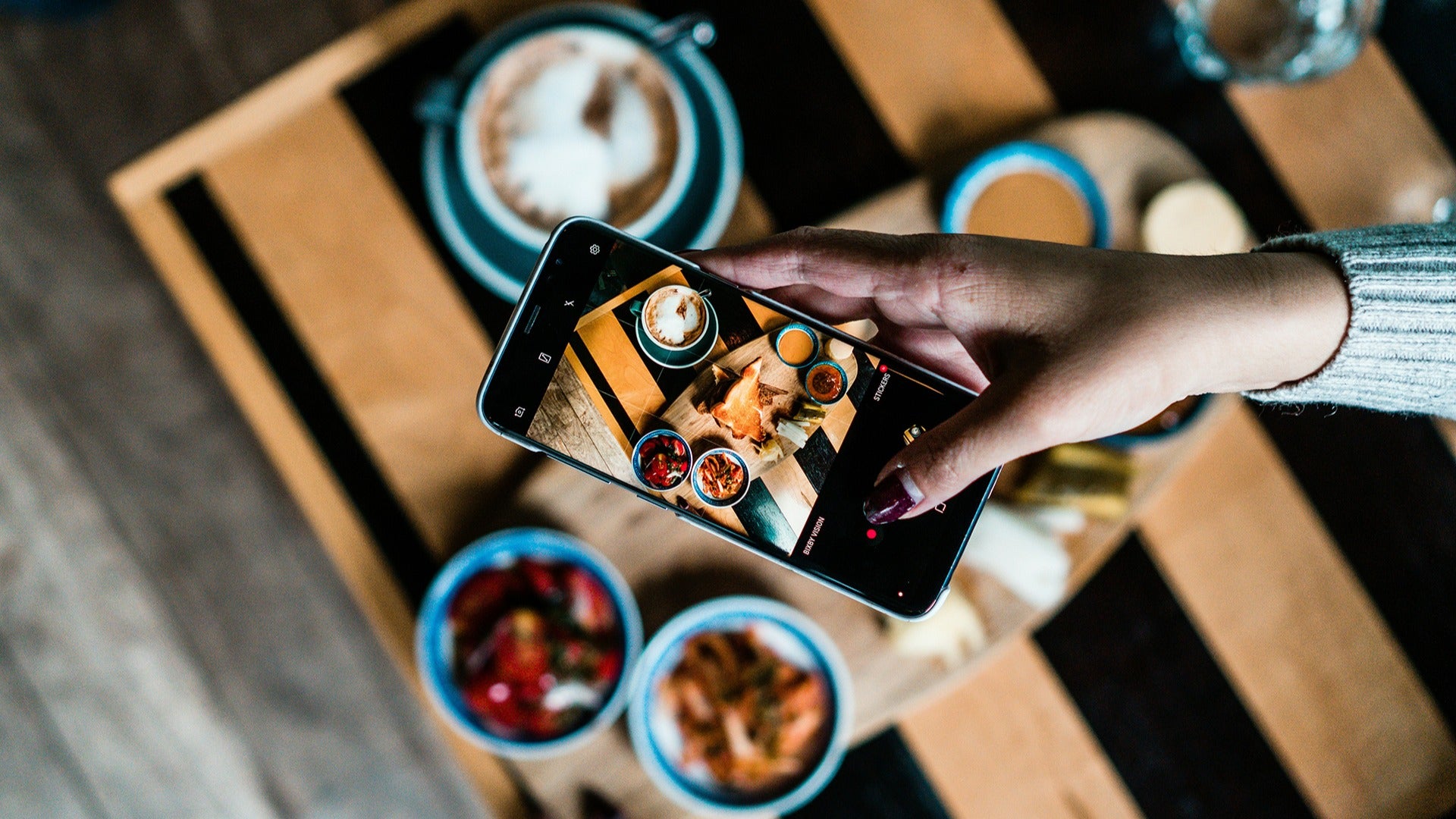 a person taking a photo of her food on a table