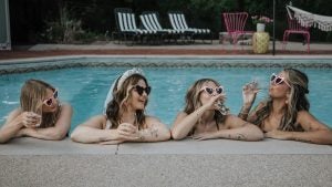 girls in the pool sipping champagne at a bachelorette party