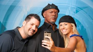 a couple taking a selfie with a samuel jackson wax figure