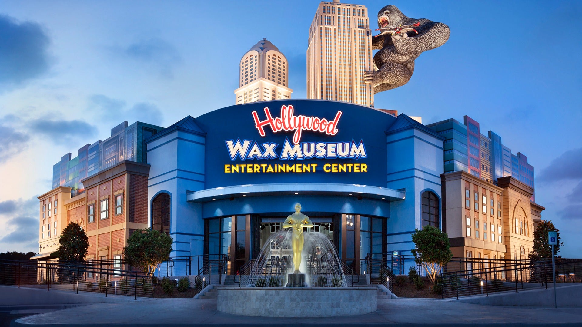 exterior of a wax museum with a grammy trophy fountain in front and king kong at the top