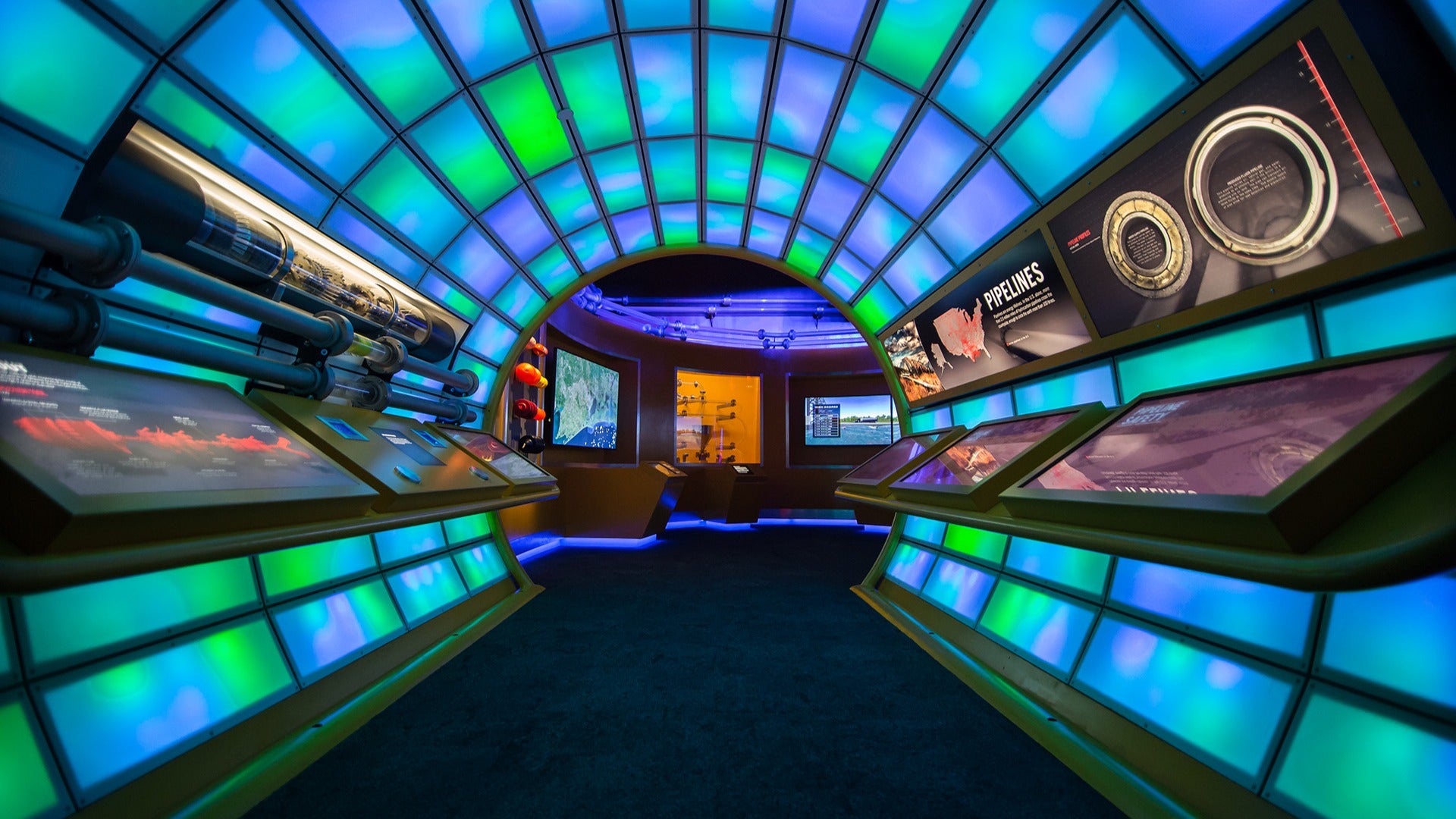 a tunnel of different colored light panels with exhibits on display