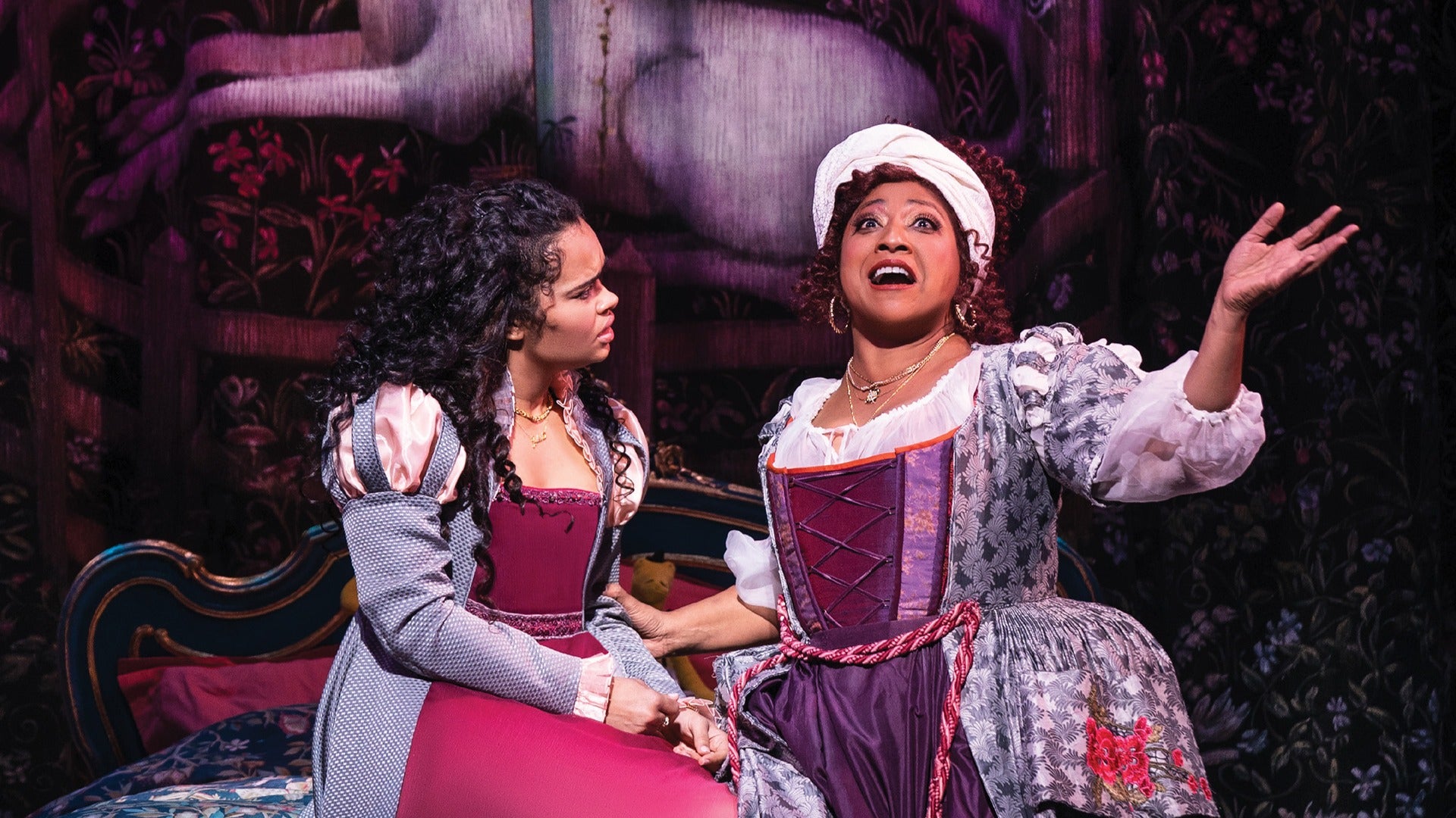 two women in costumes on stage