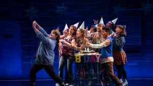 a group of actors on stage pretending to celebrate a birthday