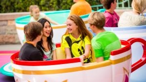 people riding a teacup ride in a theme park