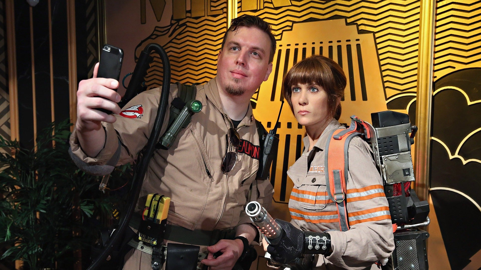 wax figures of a man and a woman in ghostbusters uniforms