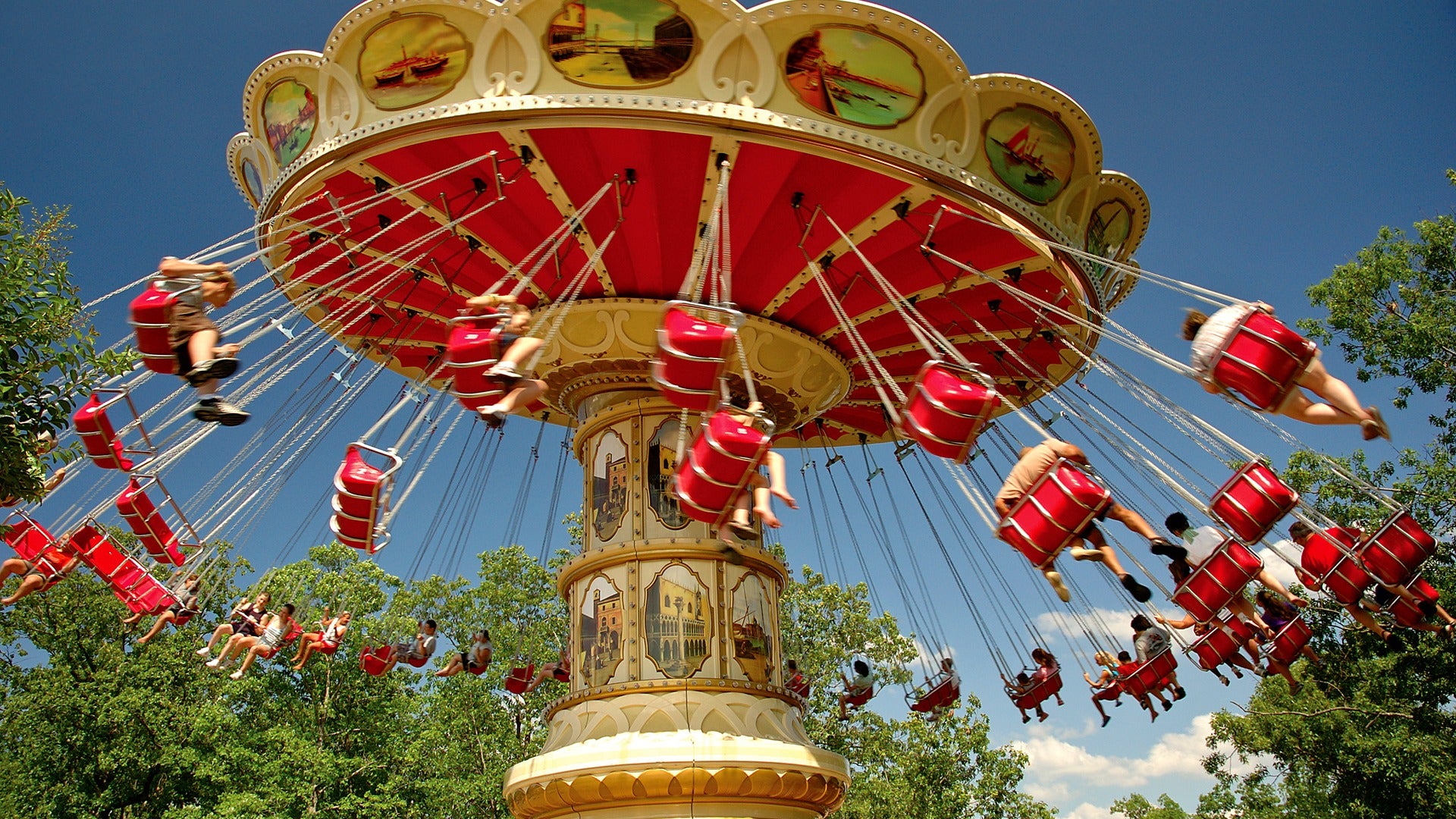 a red carousel with riders in the air