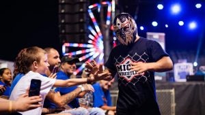 a micro wrestler shaking hands with audience