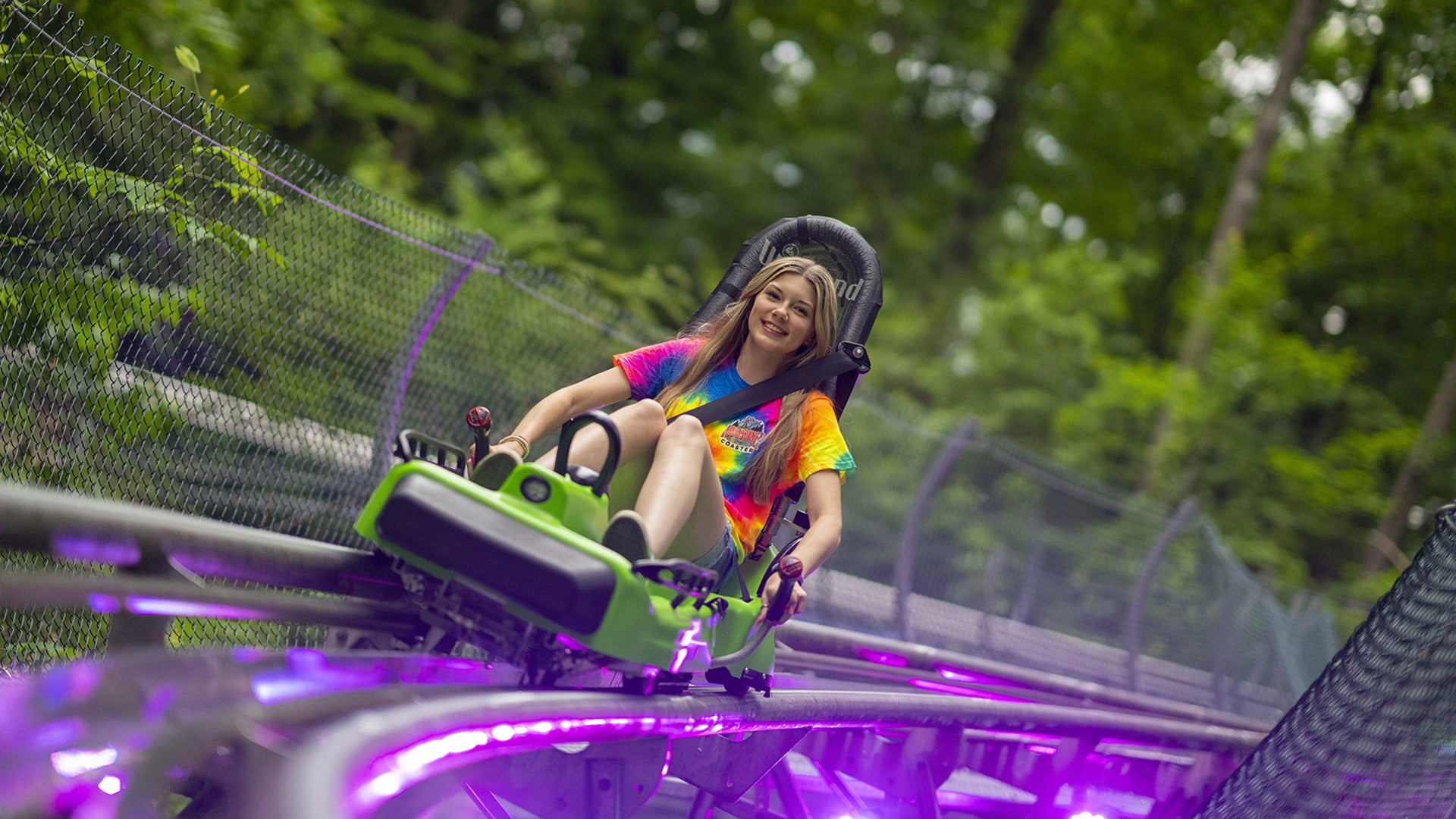 a girl riding down a mountain coaster