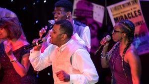 a group of singers on stage in costumes