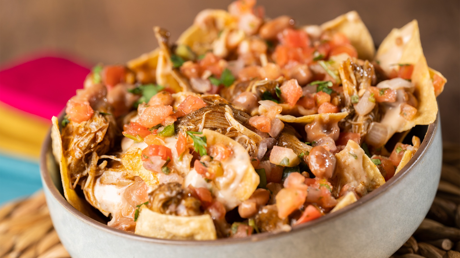 a bowl of nachos with meat and veggies