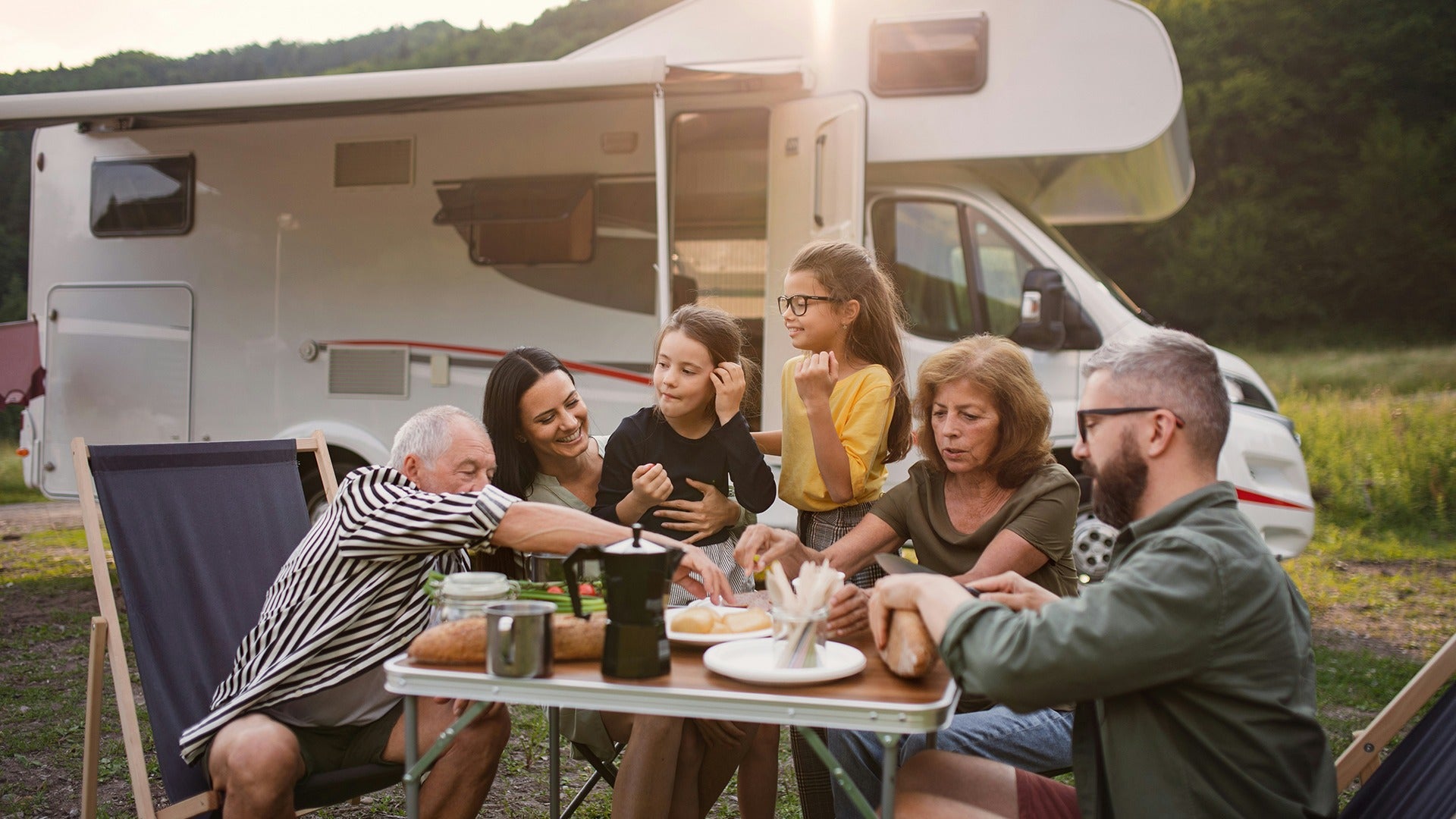 a family eating in front of an rv camper