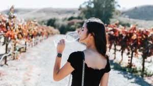 girl drinking wine in a vineyard