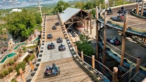 people in go karts going down different tracks