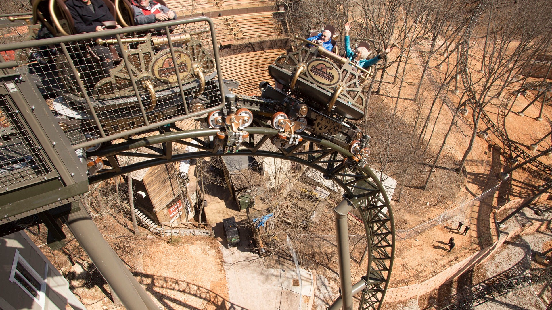Guests riding Time Traveler with arms raised on a steep drop